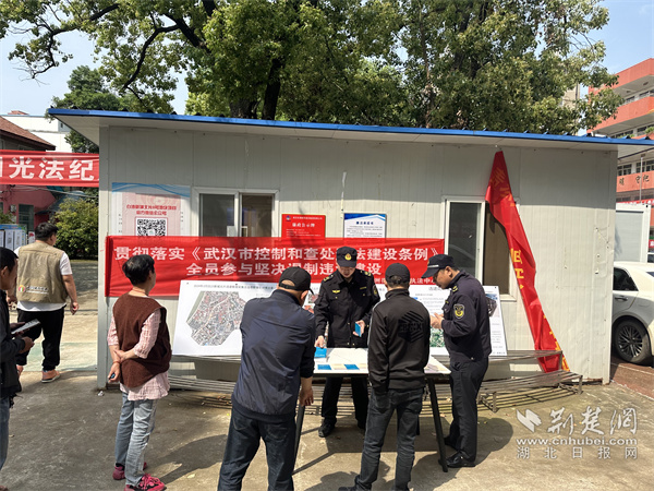 執(zhí)法隊員為居民講解違建的影響。.jpg