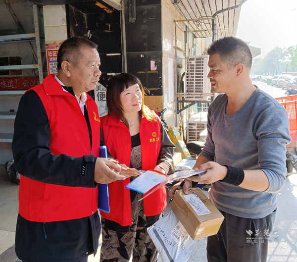 工作人員為商戶發(fā)放宣傳冊。.png.png