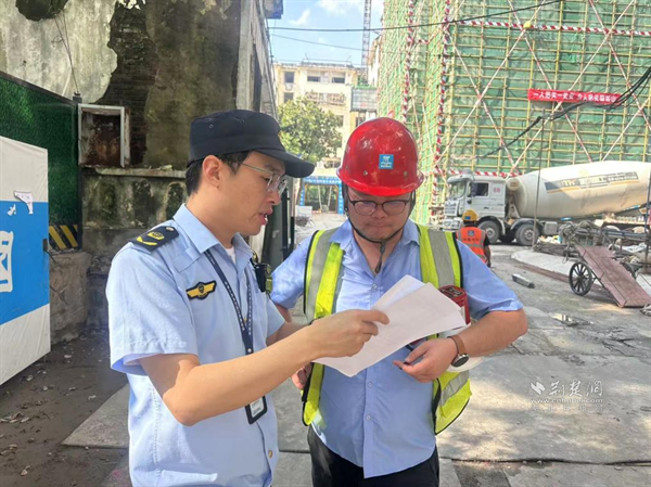 綜合執(zhí)法隊員向在建工地負責(zé)人宣傳高考期間施工規(guī)定.png.png